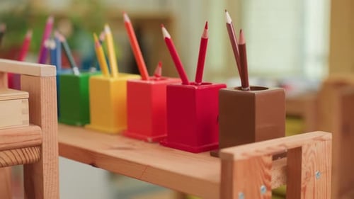 Close Up of Colorful Crayons in Holders on Wooden Shelf
