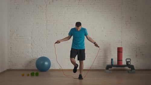 Man Fitness Coach in Sportswear Doing Jumps with Skipping Rope Cardio Exercise for Online Class at
