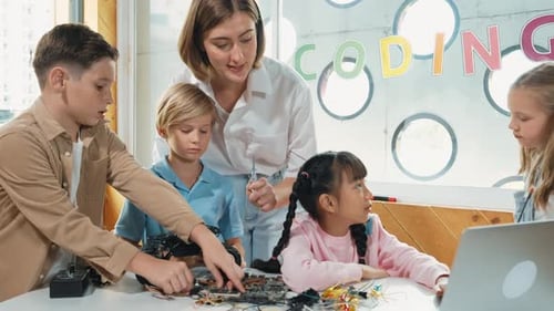 Teacher with Students Learning to Code on Laptop