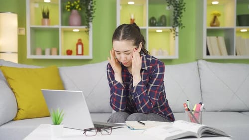 Woman Working on Laptop at Home on Sofa