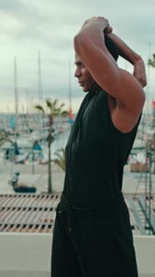 Vertical video, Young Man Stretching By The Marina