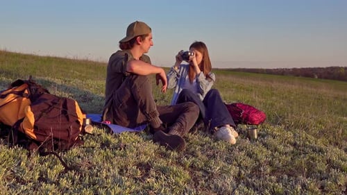 Couple Relaxing on Grassy Hillside with Vintage Camera