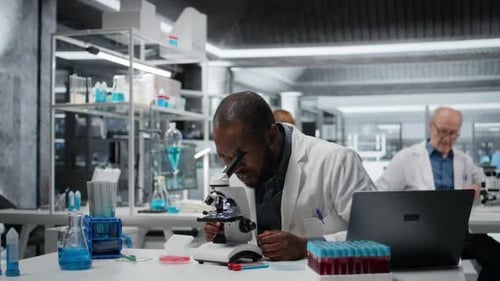 Scientist Using Microscope in Bright Modern Laboratory