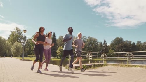 Multiethnic Sportsmen Running on Pavement Together
