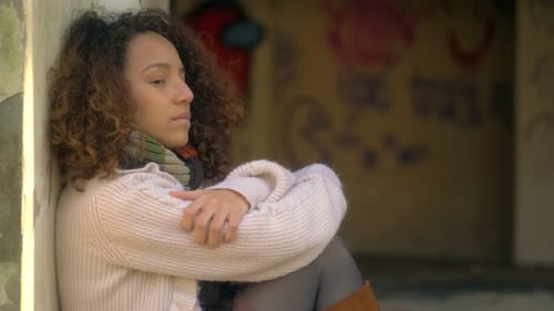 thoughts, sadness - girl leaning against the wall staring into space thinks