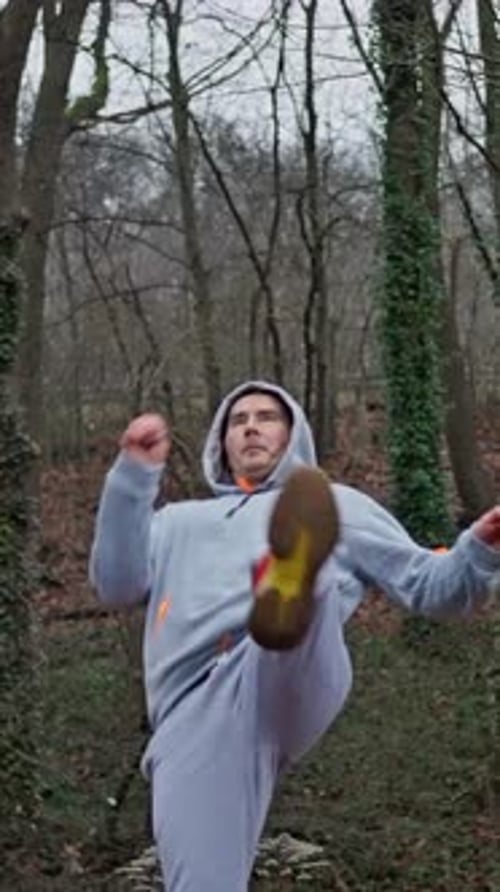 Man in Tracksuit Performs High Kick in Forest