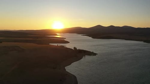 Vue aérienne du barrage et des collines au coucher du soleil