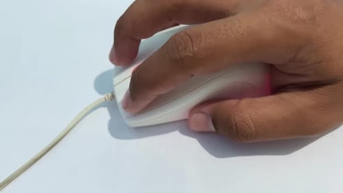 Hand of man is clicking and scrolling white computer mouse isolated in white pad. Close up of male h