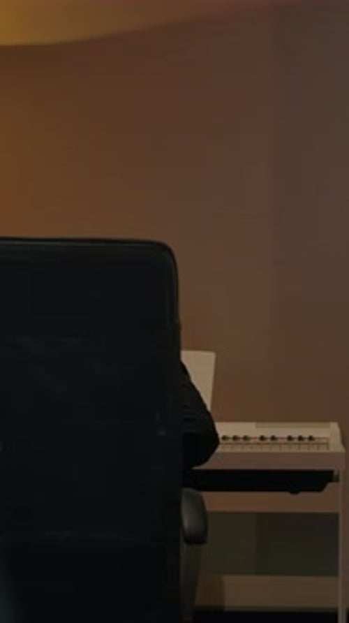 Young adult with headphones working on laptop