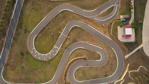 Wide lowering drone shot of a go kart track in Spain.