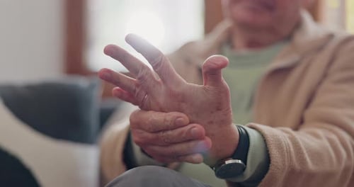 Senior Man Massaging His Hands Indoors