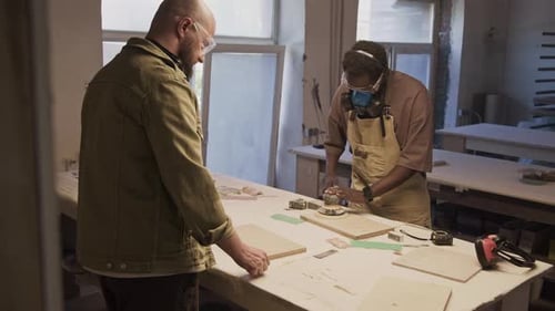 Furniture Maker Polishing Wooden Board with Electric Sander in Workshop