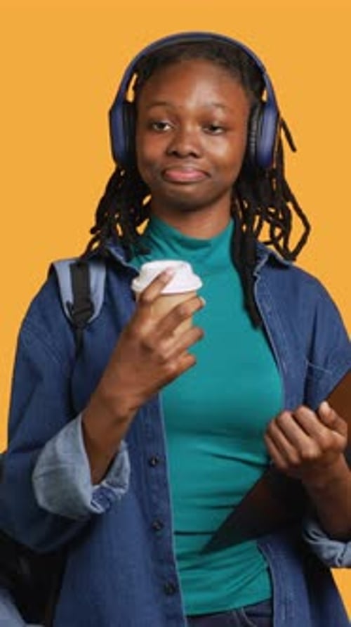 Vertical Video Teenager Drinking Caffeinated Beverage Examining Clipboard Studio Background