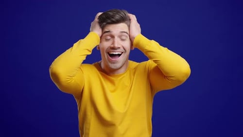 Excited Man Surprised Holding His Head in Amazement