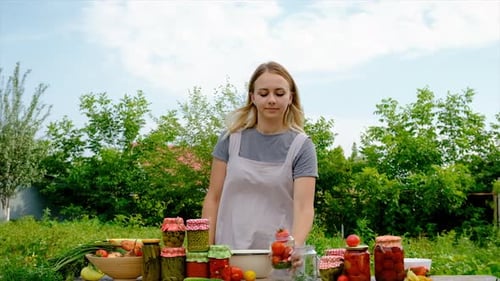 Une femme conserve des légumes dans des bocaux