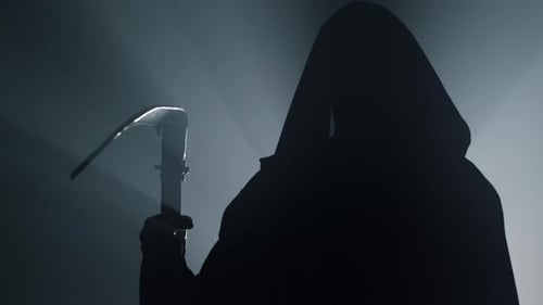 Silhouette of grim reaper with scythe standing in floodlight mystery concept