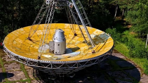 Plan rapproché d'un disque abandonné du télescope RT-32 maintenu au sol à Irbene, en Lettonie.