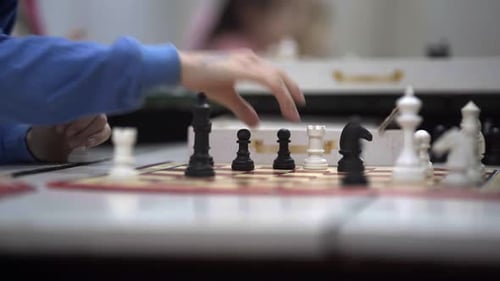 Close-up of a chessboard where two boys play during a chess lesson.