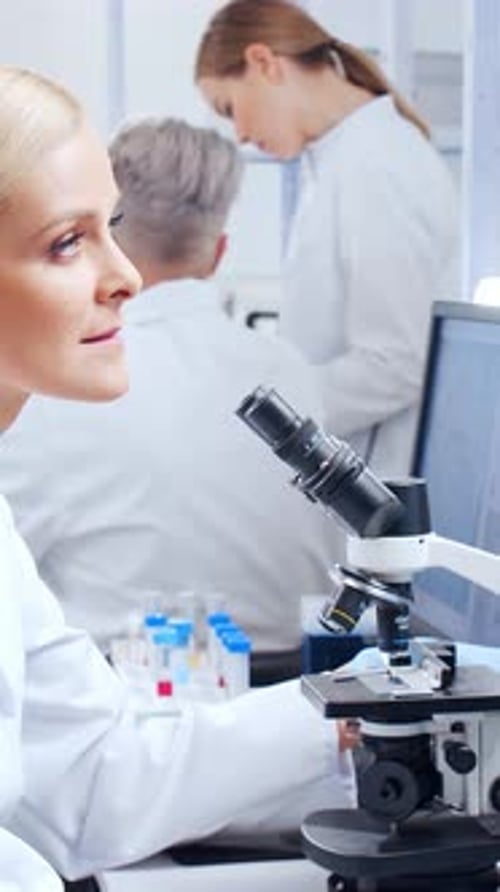 Scientist woman uses microscope in modern laboratory