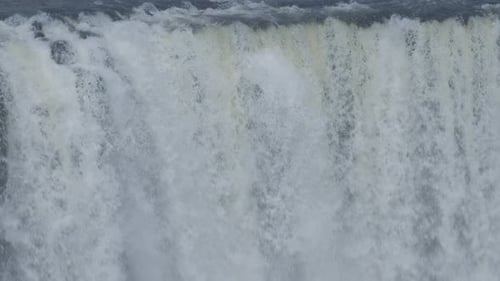 Powerful Waterfall with Strong Water Flow Surrounded By Green Trees