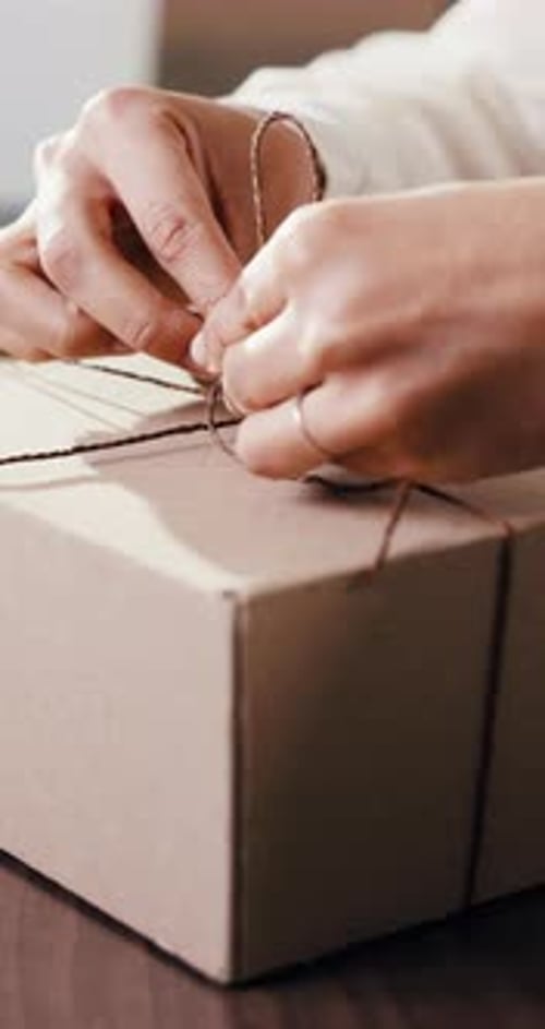Manos, envoltorio y persona con caja en la oficina para la logística, la entrega o el pedido del paquete para el servicio de mensajería