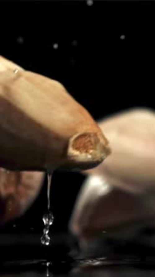Garlic Falls on a Black Table with Splashes Filmed on a Highspeed Camera at 1000 Fps