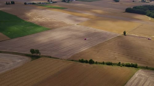 Aerial View of Tractors Working on Farm Fields