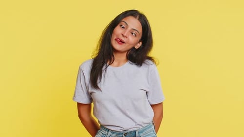 Young Woman Making Funny Faces Against Yellow Background