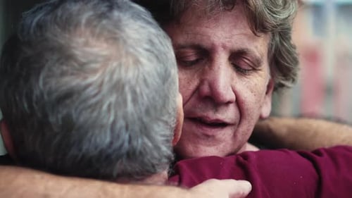 Two Elderly People Embracing in Loving Farewell, Heart-warming Candid Hug Between Senior Friends,