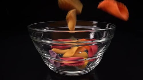 Colorful Pasta Shells Falling Into a Bowl