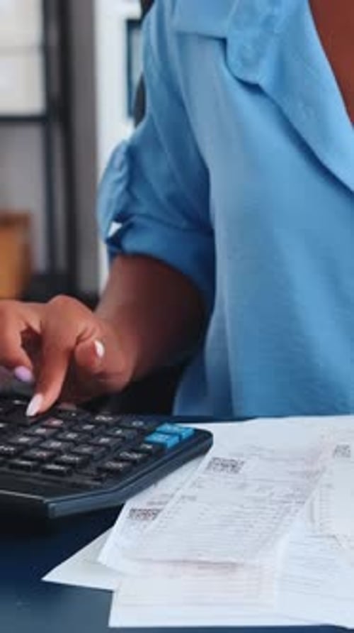 Calculating Expenses at a Cozy Desk in a Modern Workspace