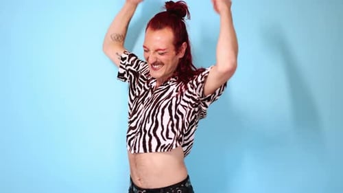 Non-binary person dancing and posing on blue background