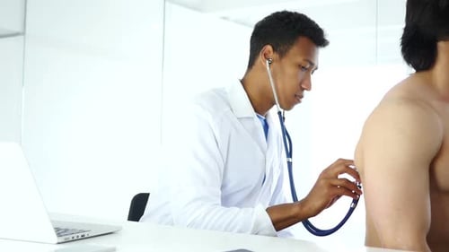 Doctor Examining Patient with Stethoscope in Clinic