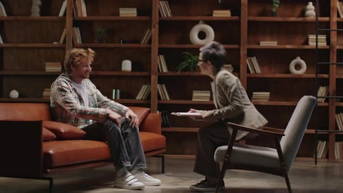 Young Man Talking to Counselor on Sofa