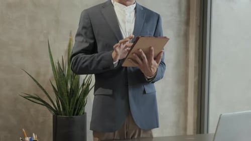Young man in Blazer Using Tablet in Office