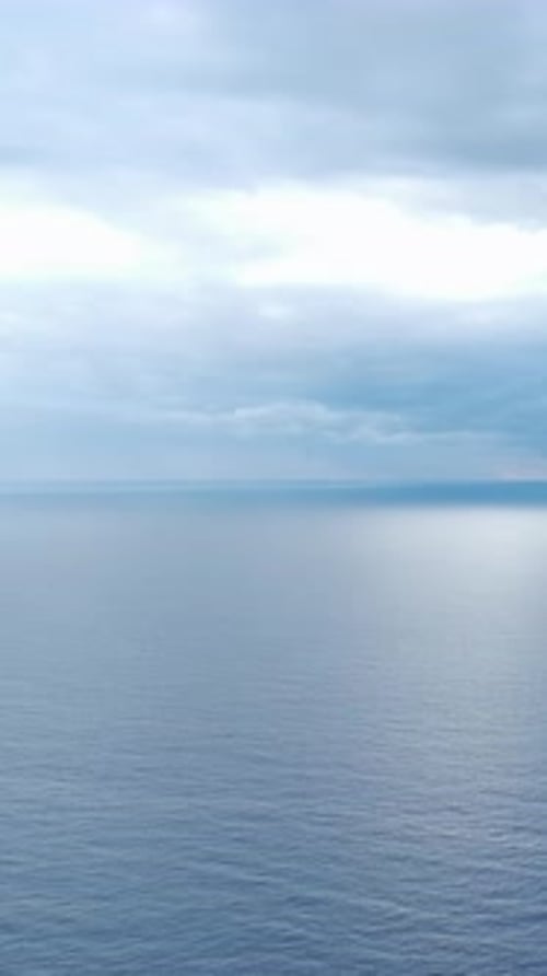Vertical Video A Magical Blue Sunset Casting Gentle Light Over the Ocean Enhancing the Water's