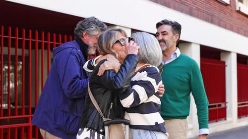 Des amis âgés heureux se saluent avec des câlins et des bisous