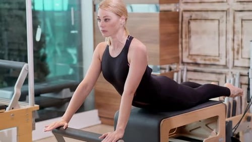 Professional Pilates Training in Gym Concentrated Blonde Woman Stretching Arms