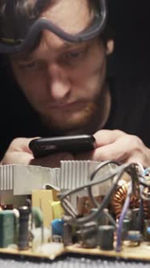 Ein Elektronikmeister mit Brille sucht im Internet nach Hilfe. Auf einem Lötkolben abgefeuert.
S