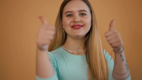 Woman Gives Two Thumbs Up in Studio Shot