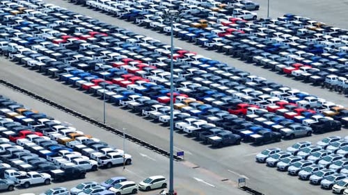 Aerial view of a parking lot full of cars in neat rows. 4K.