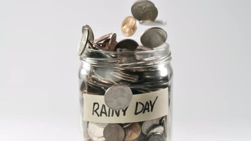 Coins Falling into Savings Jar Labeled Rainy Day