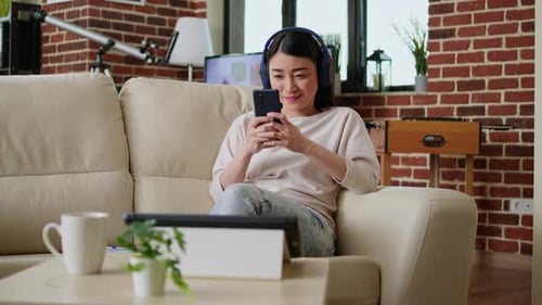 Woman Using Smartphone While Relaxing on Couch