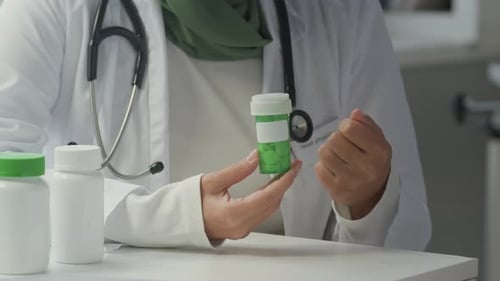 Doctor Explains Medication Holding Pill Bottle