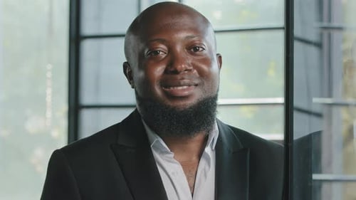 Smiling Man in Suit Standing Indoors