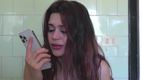Distressed Woman Crying on Cell Phone at Home