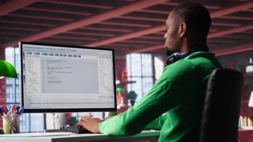 Young Adult Programmer Coding at a Desk