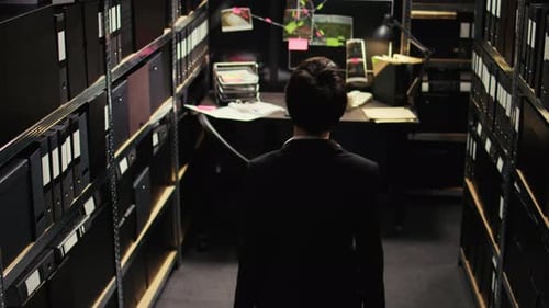 Un criminologue examine des indices contenus dans des dossiers