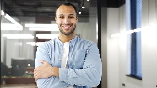 Confident Young Man Smiling in Modern Office