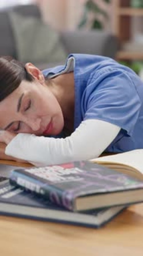 Books, education and woman medical student sleeping on desk in living room of home for break